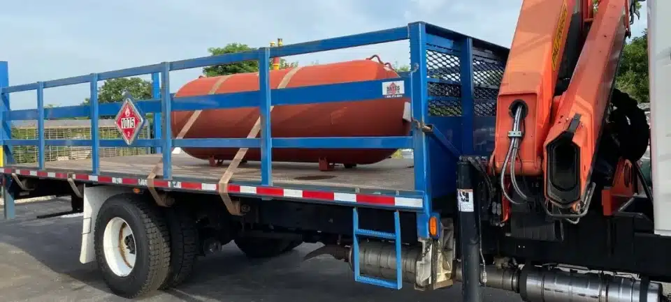 Underground propane tank strapped into truck for installation